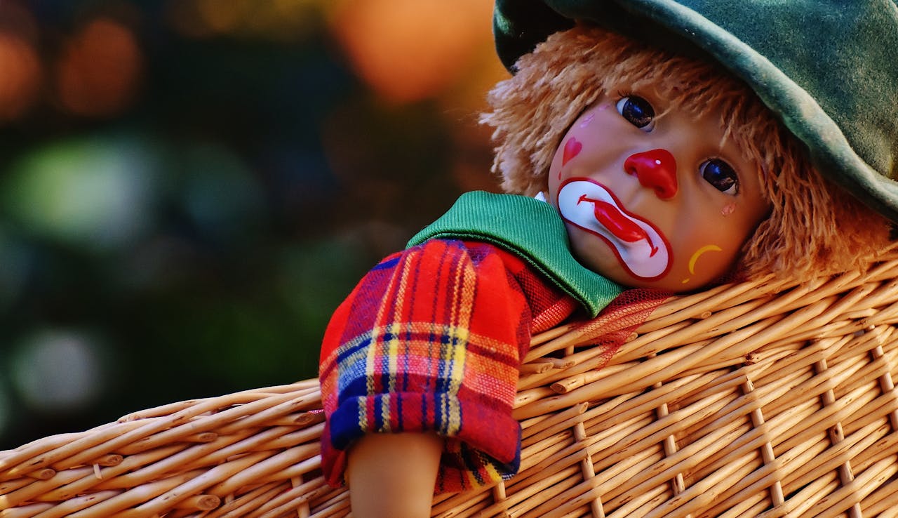 Mastering the First Impression: Your intriguing post title goes here A close-up of a colorful clown doll with a sad expression lying in a woven basket.
